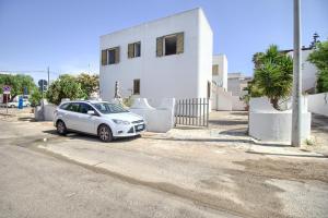a white car parked in front of a white house at Dolce Mimì by LoveSud in Marina di Pescoluse +4 photos