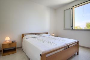 ein Schlafzimmer mit einem großen Bett und einem Fenster in der Unterkunft Dolce Mimì in Marina di Pescoluse