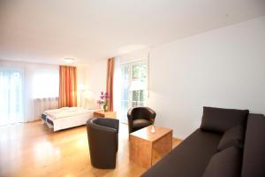 a living room with a couch and a chair at Hotelpension zum Gockl in Allershausen