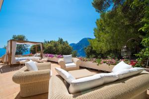 a group of chairs and couches on a patio at Hotel Piccolo Sant'Andrea in Praiano