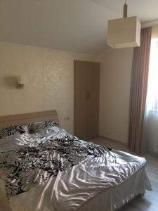 1 dormitorio con 1 cama con edredón blanco y negro en Villa Life en Zatoka