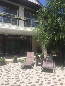 札托卡的住宿－Villa Life，房子前面的两把椅子和一张桌子