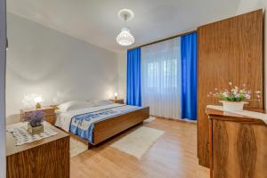 um quarto com uma cama grande e cortinas azuis em Apartment Luce em Podstrana