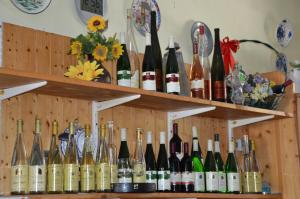 kilka butelek wina na półkach w obiekcie Wein & Gästehaus Ballmann w mieście Trittenheim