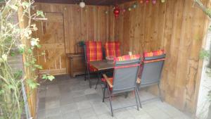 a patio with a table and chairs in a fence at Lardinois vakantieverhuur in Beutenaken