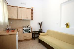 a living room with a couch and a kitchen at Anastasia Studios in Tinos