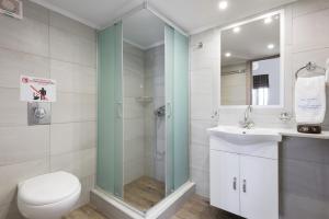 a bathroom with a shower and a toilet and a sink at Vlycha Beach Apartments in Lindos