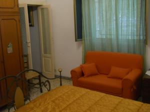フランカヴィッラ・フォンターナにあるVilla Conte in Salentoのベッド1台、椅子、ソファが備わる客室です。