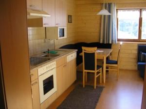 eine kleine Küche und ein Esszimmer mit einem Tisch in der Unterkunft Appartement Bischof in Schoppernau
