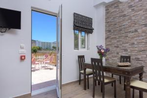 comedor con mesa, sillas y ventana en Vlycha Beach Apartments, en Lindos
