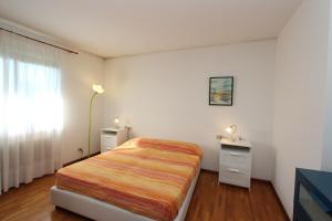 a bedroom with a bed and a dresser and a window at Attico Magnolie in Cividale del Friuli