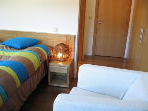 a bedroom with a bed and a table with a lamp at Quinta dos Castanheiros - Turismo Rural in Negreda