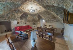 ein Wohnzimmer mit einem roten Sofa und einem Tisch in der Unterkunft Palazzo Cestari Hotel in Montesano sulla Marcellana