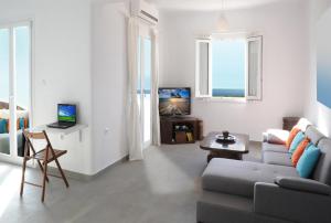 プラカにあるEvriali Beachfront Luxuryの白いリビングルーム(ソファ、テレビ付)