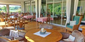 un restaurante con mesa, sillas, mesas y sillas en Landhaus Ostseeblick en Kronsgaard