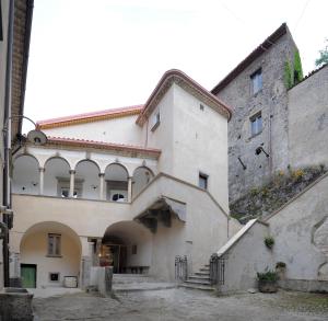 un grand bâtiment avec une arche dans une cour dans l'établissement Palazzo Cestari Hotel, à Montesano sulla Marcellana