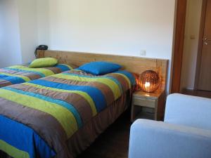 two beds in a room with a lamp on a table at Quinta dos Castanheiros - Turismo Rural in Negreda