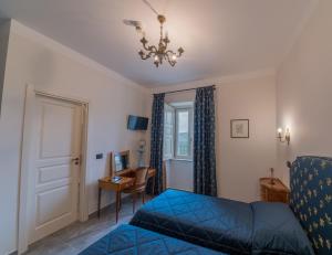Un dormitorio con una cama azul y una lámpara de araña. en Palazzo Cestari Hotel, en Montesano sulla Marcellana