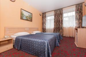 ein Hotelzimmer mit 2 Betten und einem TV in der Unterkunft Regina na Baumana in Kasan