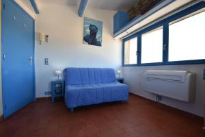 ein blaues Sofa in einem Zimmer mit Fenstern in der Unterkunft Le Provence Plage in La Seyne-sur-Mer