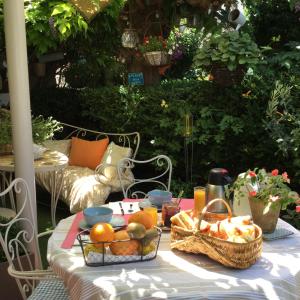 a table with a basket of fruit on it at Hotel Le Méditérranée in Saintes-Maries-de-la-Mer