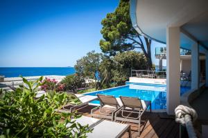 a swimming pool with chairs and a view of the beach at Royal Neptun Hotel in Dubrovnik