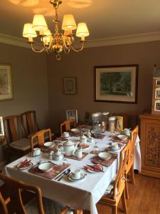 a dining room table with a white table cloth at Rose Villa Bed and Breakfast in Forfar