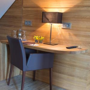 einen Schreibtisch mit einem Stuhl und einer Lampe an der Wand in der Unterkunft Truschwende 4 in Bad Wurzach