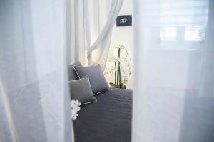 een slaapkamer met witte gordijnen en een bed met kussens bij Relais Dolcevita in Rome