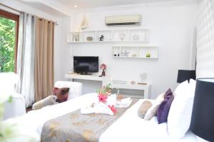 a white room with a bed and a tv at Lio Villas Resort in El Nido