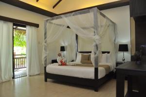 a bedroom with a bed with a canopy at Lio Villas Resort in El Nido