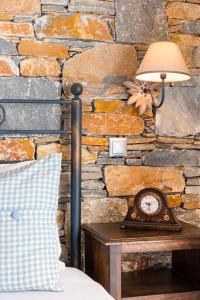 a lamp on a table next to a stone wall at Akrogiali in Posidhonía