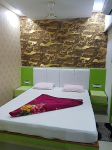 a bedroom with a white bed with a red blanket at Hotel Laabh in Diu