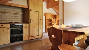 a kitchen with wooden cabinets and a stove top oven at Ferienappartements Beck in Malbun