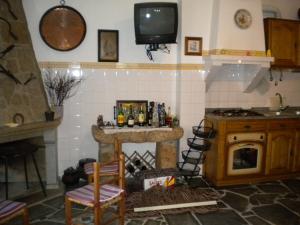 a kitchen with a fireplace and a tv on the wall at Casa da Bemposta in Bemposta