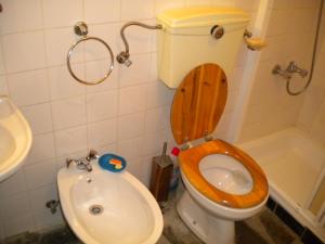 a bathroom with a toilet with a wooden seat and a sink at Casa da Bemposta in Bemposta
