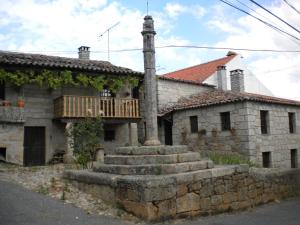 een oud stenen huis met een veranda en een trap buiten bij Casa da Bemposta in Bemposta