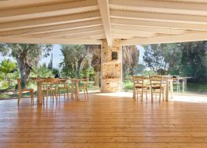 una sala da pranzo con tavoli e sedie in legno di Via dei Mari Guest House a Oristano