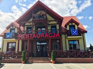 a restaurant with a sign on the front of a building at EdMar in Malbork