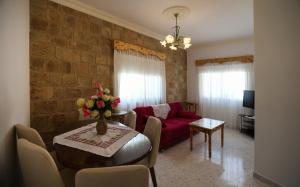 a living room with a table and a red couch at Tyre Boutique Apartments in Soûr