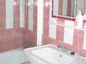 a bathroom with a sink and a tub and a mirror at Casa Rural Corvina in Acebo