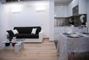 een woonkamer met een zwarte bank en een tafel bij Relais Dolcevita in Rome