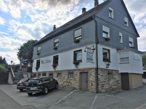 a building with a car parked in front of it at Landgasthof Drei Eichen in Wilnsdorf