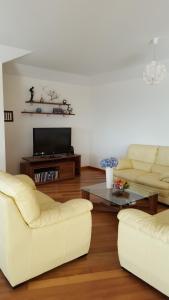 een woonkamer met twee witte banken en een salontafel bij V.I.P. Baia in Machico