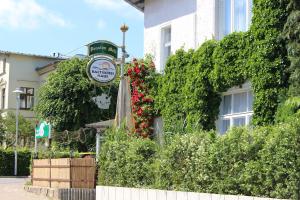 a building with a sign and flowers in front of it at Baltisches Haus Pension Moll in Zinnowitz