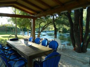 a wooden table and chairs under a pavilion next to a river at Vacation Home Katarina in Čapljina