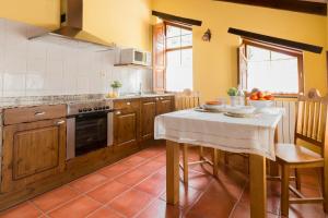 a kitchen with a table with a white table cloth at Casa Gayón in Pola de Allande