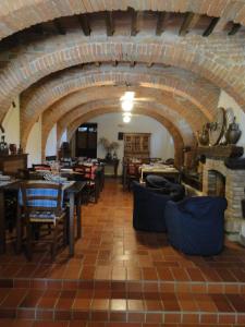 jadalnia ze stołami i krzesłami oraz ceglaną ścianą w obiekcie Agritur Villa Osvaldo Castiglione del Lago Perugia Colazione Piscina acqua salata w mieście Castiglione del Lago