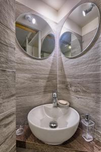 波隆那的住宿－Appartamento Margherita，浴室设有白色水槽和两面镜子