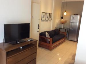 uma sala de estar com um sofá e uma televisão de ecrã plano em Ipa Penthouse Prudente no Rio de Janeiro